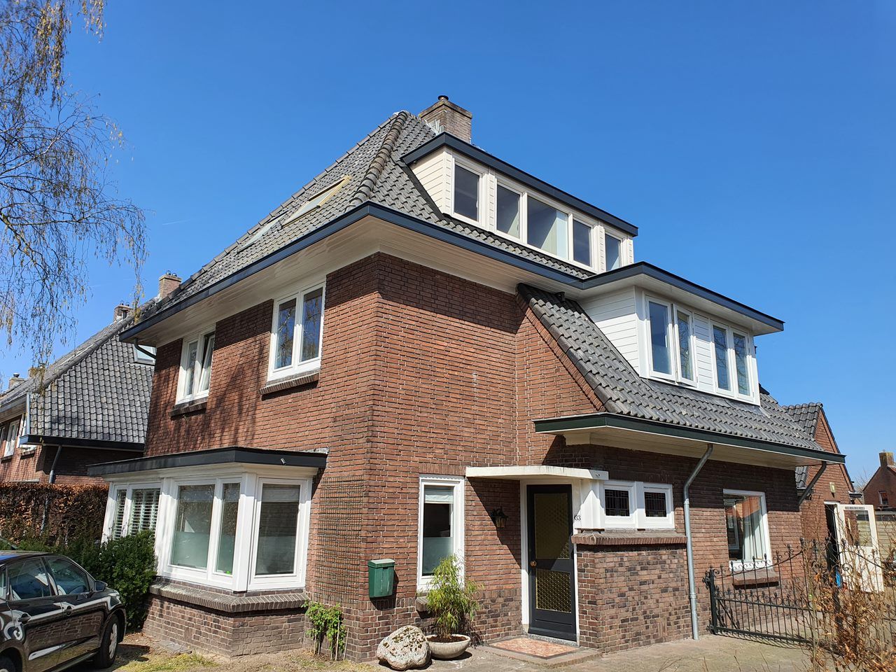 Bakstenen villa met dakkapellen en wit schilderwerk